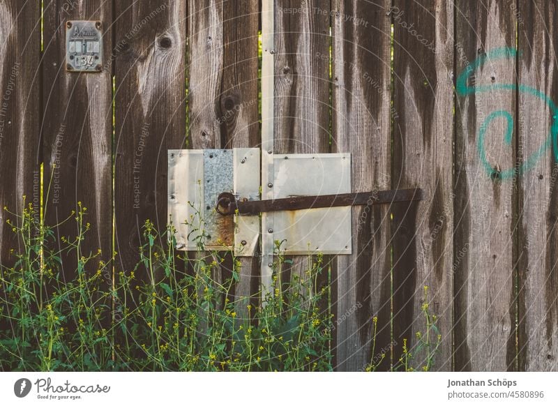 locked gate made of wood and metal Goal Closed Boundary line Wood Metal Flat Fence plants become overgrown Entrance door Old Safety Lock Structures and shapes