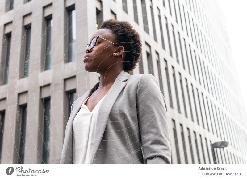 Stylish confident black businesswoman near modern office building entrepreneur city skyscraper street classy downtown eyeglasses jacket manager well dressed