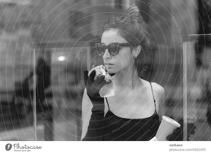 portrait of a cheerful young elegant caucasian woman wearing a tube black dress , having a croissant and a coffee for breakfast in a violin shop, vintage classic elegance concept