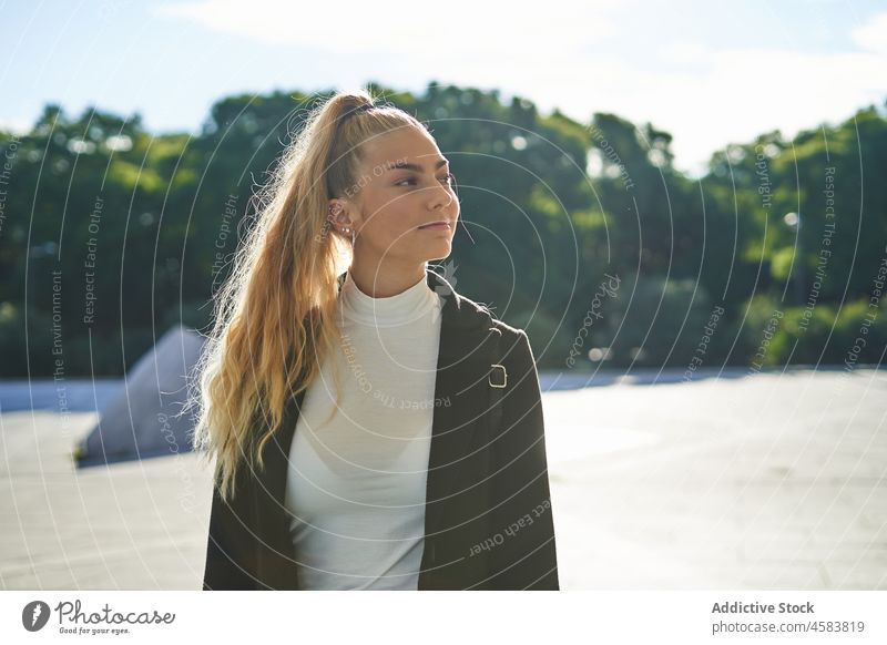 Young woman walking on square of city in sunny day street stroll urban town backpack black young pavement sidewalk modern casual pedestrian architecture