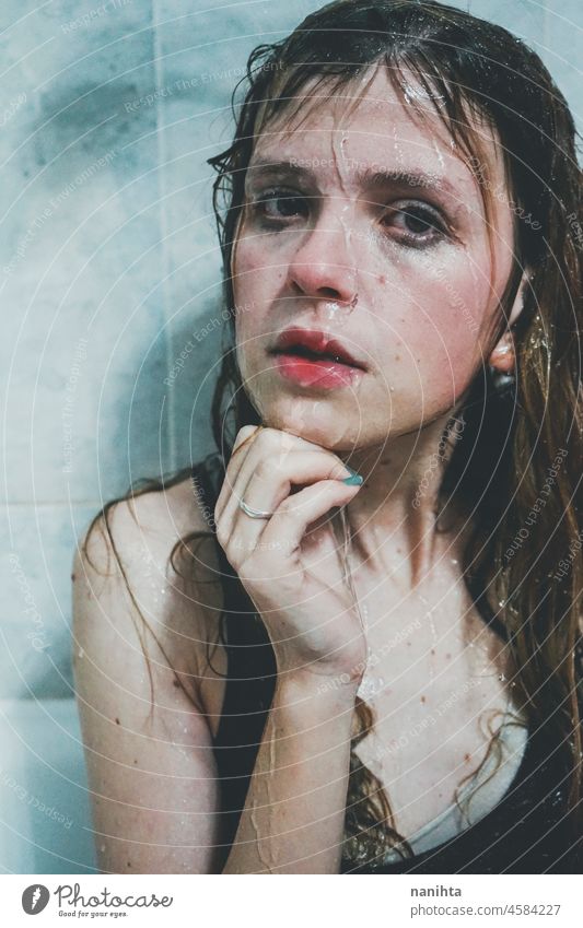 Artistic portrait of a young woman under shower water attractive fresh art artist face wet close natural real pretty long hair sensual sexy make up bath