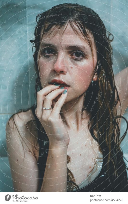 Artistic portrait of a young woman under shower water attractive fresh art artist face wet close natural real pretty long hair sensual sexy make up bath