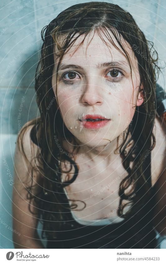 Artistic portrait of a young woman under shower water attractive fresh art artist face wet close natural real pretty long hair sensual sexy make up bath