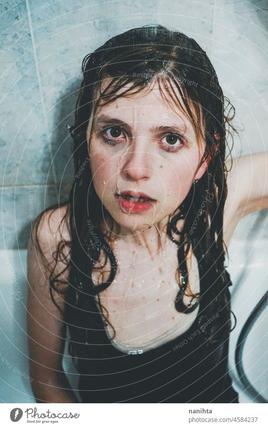 Artistic portrait of a young woman under shower water attractive fresh art artist face wet close natural real pretty long hair sensual sexy make up bath