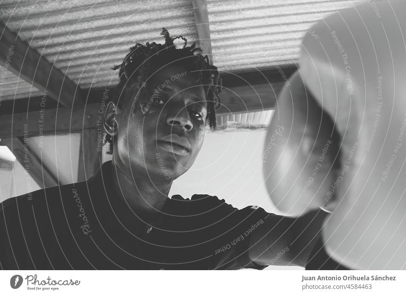 Black and white portrait of a young very handsome black man wearing boxing gloves young man sexy B&W fashionable urban style sportsman strong guy male serious