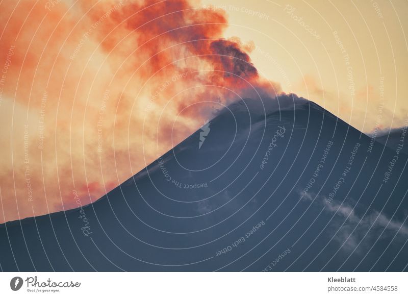 Etna - thick black ash clouds above the crater peak - the evening sun makes the clouds glow red Mount Etna Volcano active Sicily natural spectacle wok Sunset