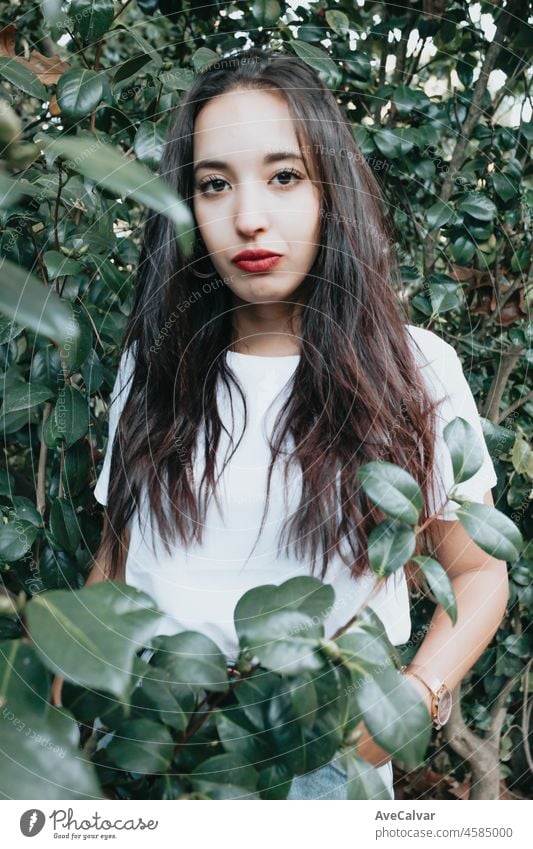 African arab young girl between green leaves smiling and saluting to camera. Natural isolated. Social network day at nature concept. Beauty portrait. Copy space for text and adds. Health. Serious