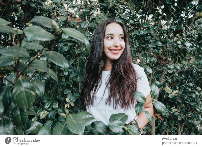 African arab young girl between green leaves smiling and saluting to camera. Natural isolated. Social network day at nature concept. Beauty portrait. Copy space for text and adds. Health.