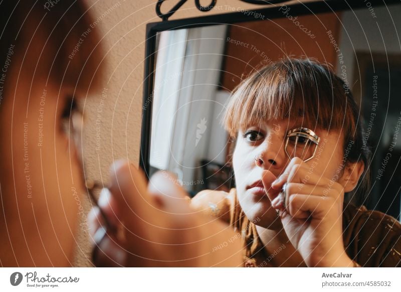 Young woman using eye make up contours applying lipstick doing make up at home getting ready and beauty. Looks in the mirror, paints her eyes with black eyeliner. Close-up.Beauty and self care make up