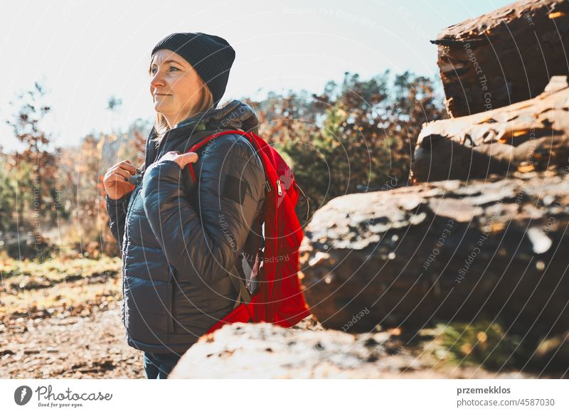 Woman enjoying hike on sunny vacation day. Female with backpack walking through forest trip hiking adventure travel summer journey wanderlust hiker exploring