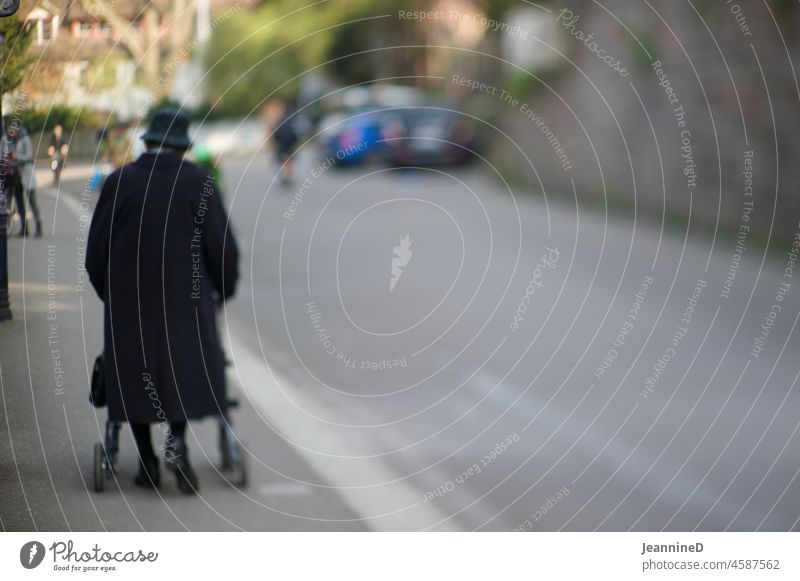 old lady with walker walking in the city To go for a walk stroll Walking aid City life Winter on one's own Lonely blurriness Loneliness Going Old frail