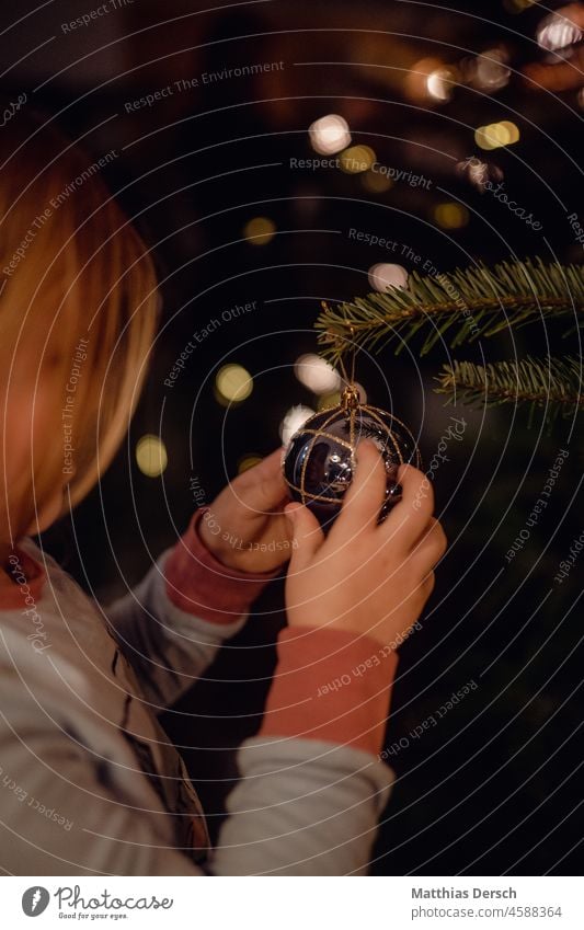 A girl decorates a Christmas tree Christmas & Advent Christmas decoration Decoration Feasts & Celebrations Winter Festive Christmas tree decorations Moody