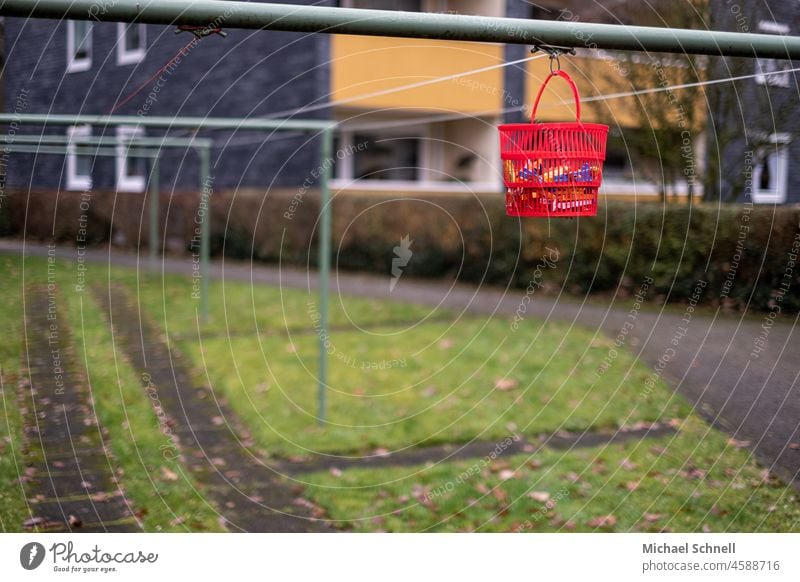 Red hanging basket with clothes pegs on the clothesline Basket Laundry Clothes peg Dry urban urban life Washing Washing day Clean Hang Hang up Exterior shot