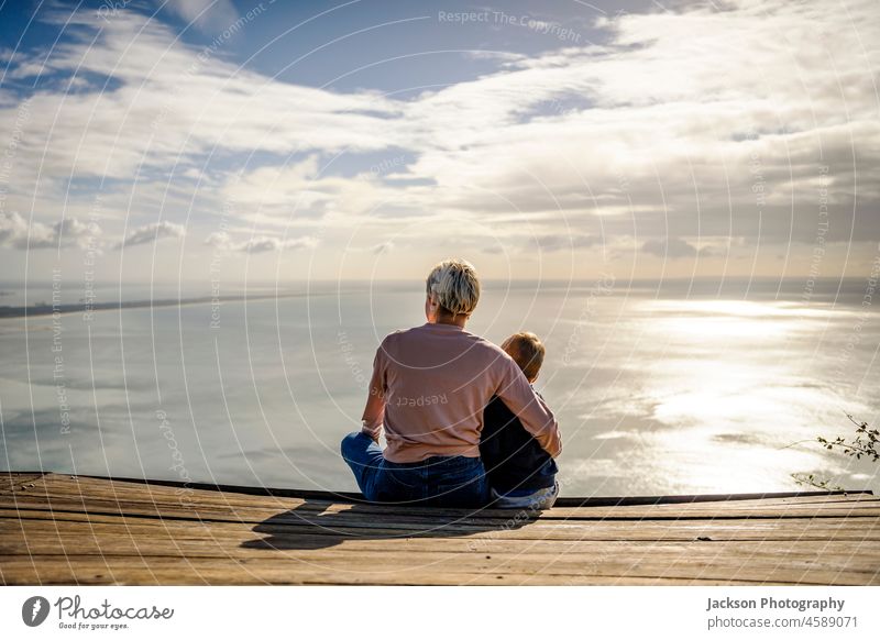 Mother and 3 years old son hugging each other and enjoying the beautiful ocean views kid mother nature boy child happy parent family childhood together woman