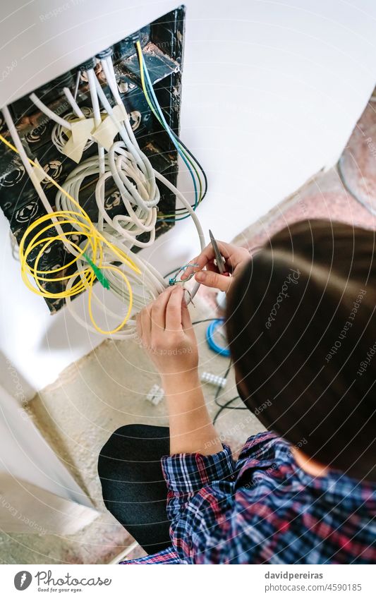 Unrecognizable female technician installing lan network top view unrecognizable installer telecommunication cable telecommunications box scissors woman