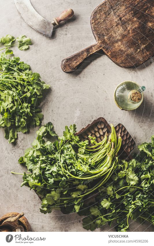 Fresh parsley on kitchen table with wooden cutting board and herbs knife. Cooking at home with healthy and flavorful ingredients. Top view. fresh cooking