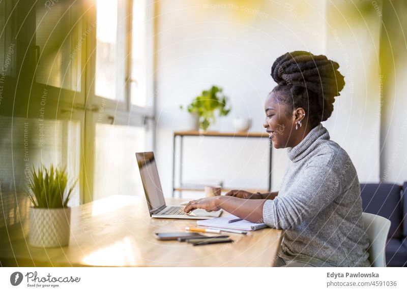 Woman working on laptop in her office black millennials hipster indoors loft window natural adult one attractive successful people confident person beautiful