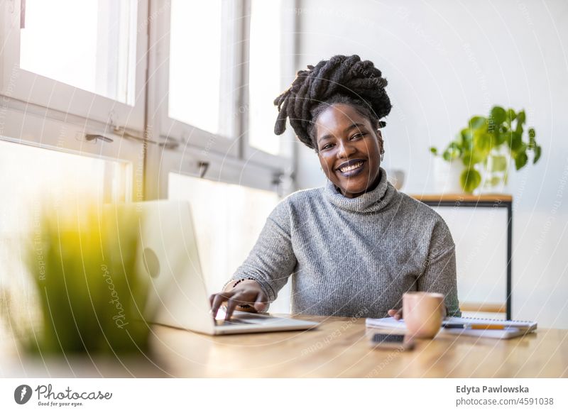 Woman working on laptop in her office black millennials hipster indoors loft window natural adult one attractive successful people confident person beautiful