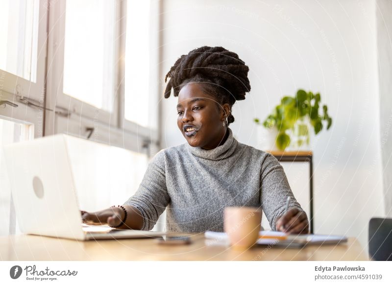 Woman working on laptop in her office black millennials hipster indoors loft window natural adult one attractive successful people confident person beautiful