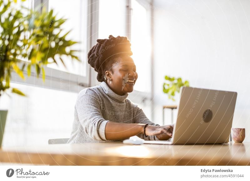 Woman working on laptop in her office black millennials hipster indoors loft window natural adult one attractive successful people confident person beautiful