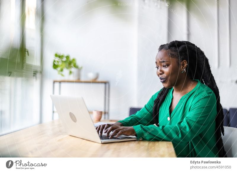 Woman working on laptop in her office black millennials hipster indoors loft window natural adult one attractive successful people confident person beautiful