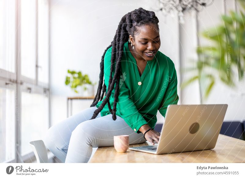 Woman working on laptop in her office black millennials hipster indoors loft window natural adult one attractive successful people confident person beautiful