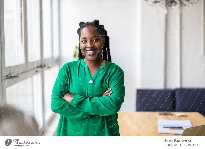 Portrait of a smiling creative woman in a modern loft office black millennials hipster indoors window natural adult one attractive successful people confident