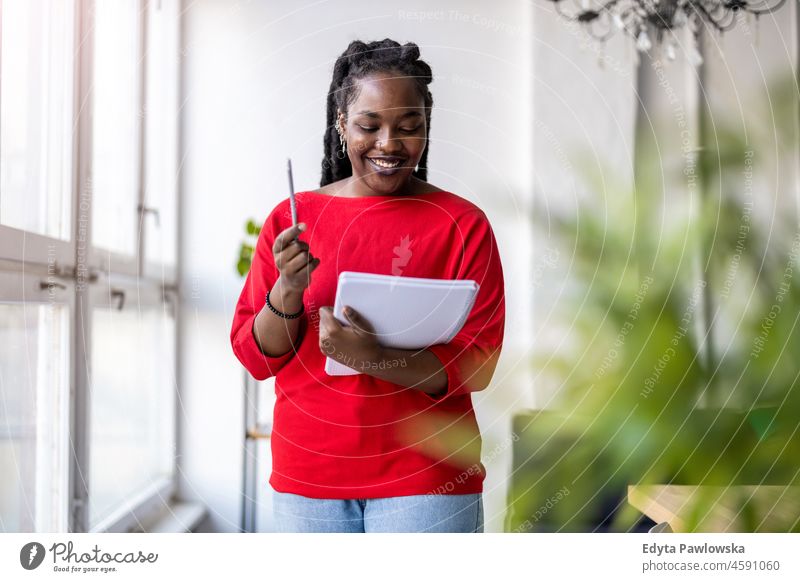 Portrait of a smiling creative woman in a modern loft office black millennials hipster indoors window natural adult one attractive successful people confident