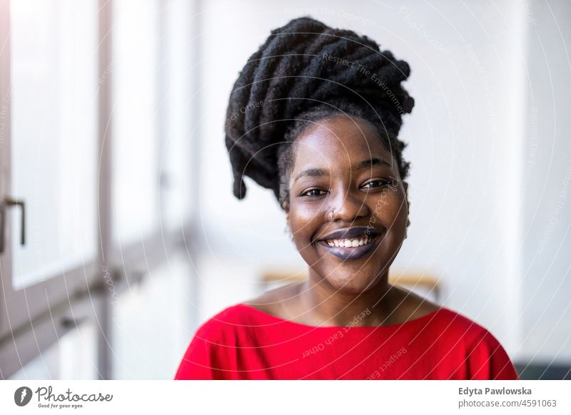 Portrait of a smiling young woman indoors black millennials hipster loft window natural adult one attractive successful people confident person beautiful female