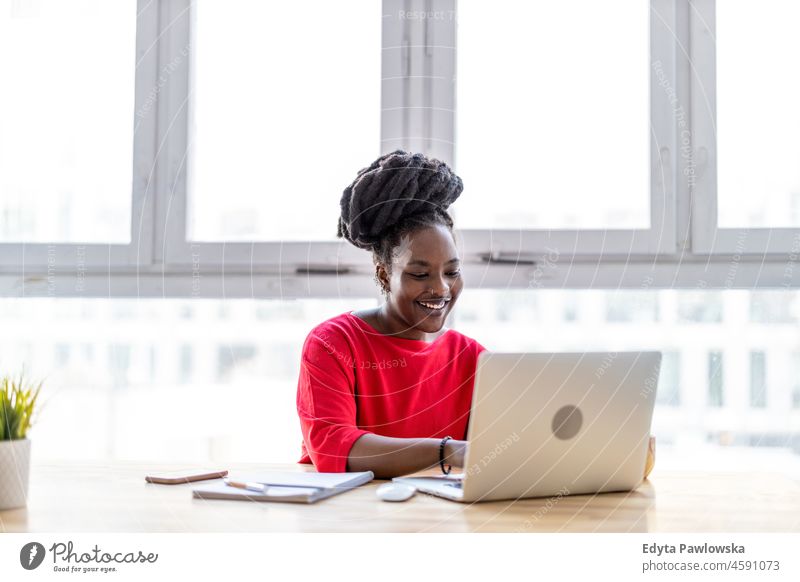 Woman working on laptop in her office black millennials hipster indoors loft window natural adult one attractive successful people confident person beautiful