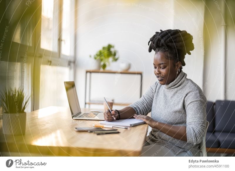 Woman working on laptop in her office black millennials hipster indoors loft window natural adult one attractive successful people confident person beautiful