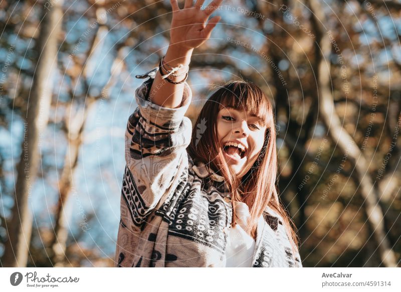 Young curvy red head woman surprised and pointing something outdoors with copy space. Postal card concept. Ad and advertising. Waves her hand, greeting. female