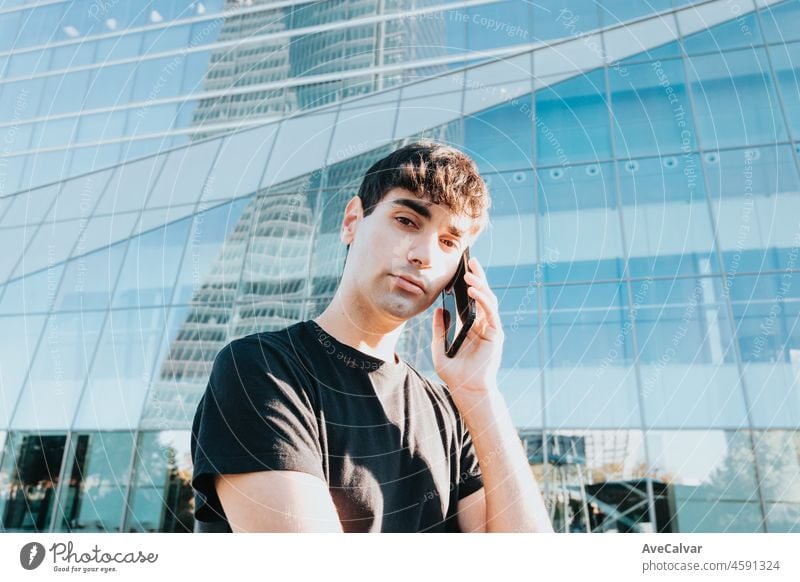 Young business man going to work receiving calls in front of a office building in city outdoors. Copy space mobile phone businessman male people technology bank