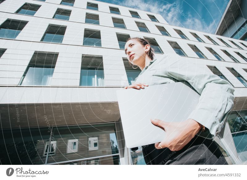 Young african american businesswoman smiling happy walking holding a laptop at the city. Quickly goes to work late in the hands of holding a laptop with a work report.Professional Manager copy space