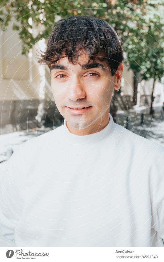 Close up of a young man with looking to camera with intensity. Portrait concerning mental health and worry about a new phase in his life. person eyes handsome