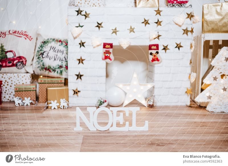 beautiful christmas decoration at home. Chimney, gifts, tree, noel, cushions on beautiful indoor white studio. Christmas concept. Nobody chimney evening bright