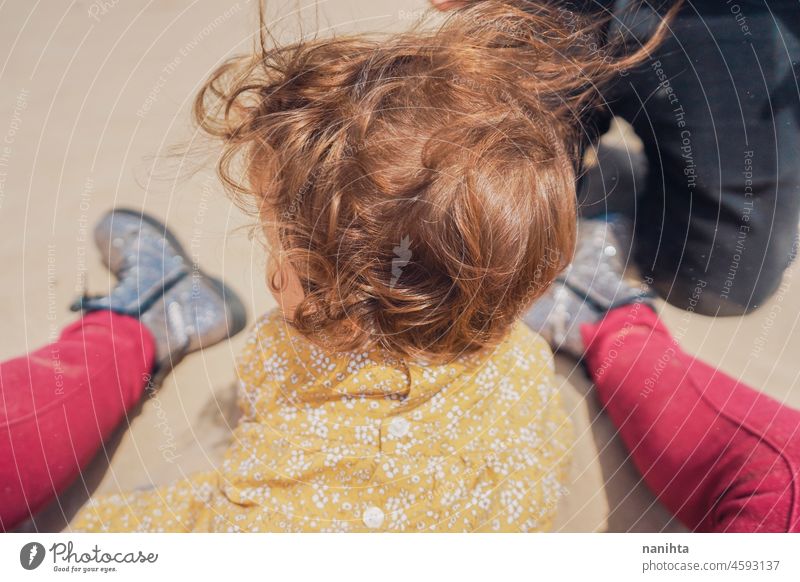 Baby playing in the sand with their parents mom family motherhood vacation happiness baby happy playful fun funny childhood parenthood parenting casual candid