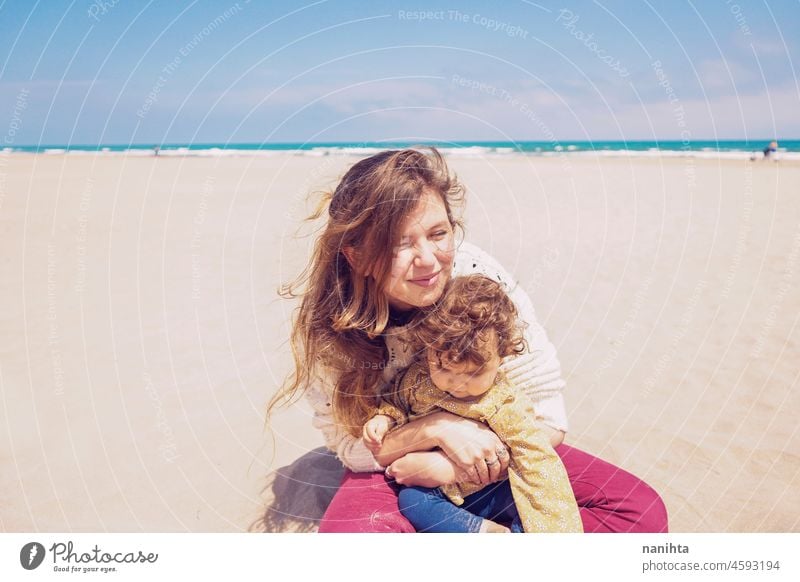 Young mom playing at the beach with her child baby family holidays single parent parenting motherhood young youth blonde playful fun funny happy happiness