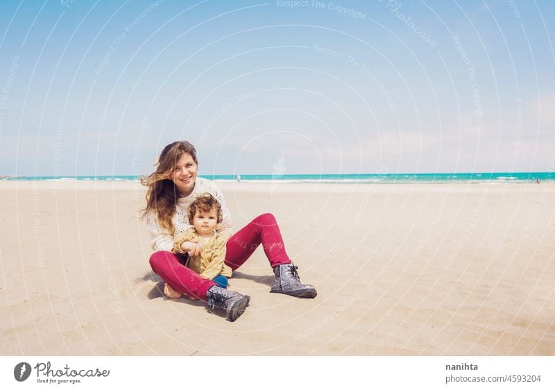 Young mom playing at the beach with her child baby family holidays single parent parenting motherhood young youth blonde playful fun funny happy happiness