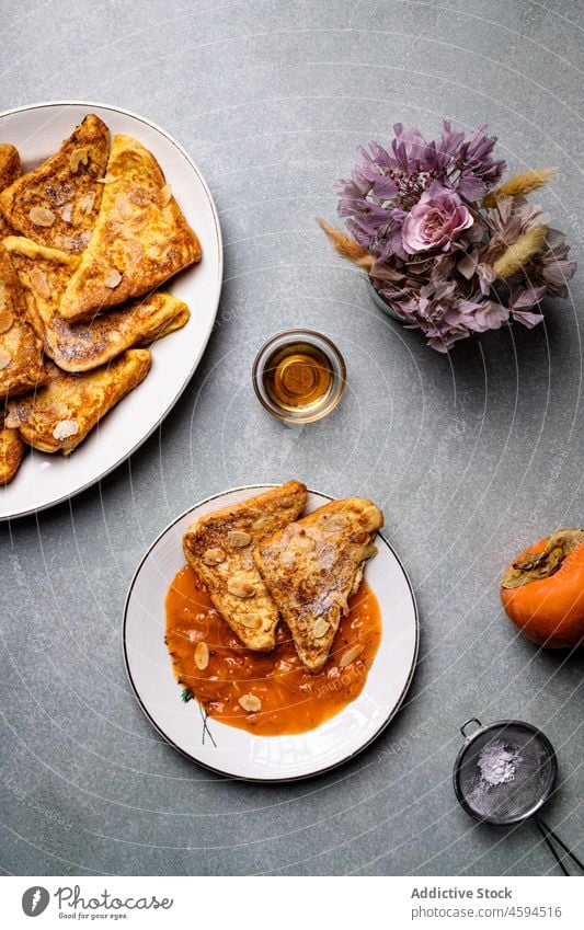 Plate with French toasts placed near persimmons on gray table honey delicious jar breakfast food dessert plate sweet portion yummy nutrition tasty healthy sugar