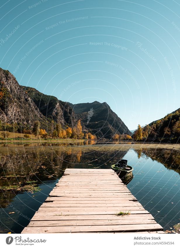 Wooden pier on calm water and moored boat river wooden lumber nature tranquil timber vessel picturesque quay serene waterfront idyllic surface dock scenic