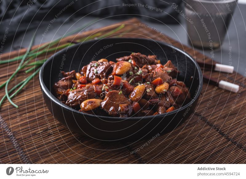 Bowl of delicious dish with stewed Asian chicken meal chives chopstick tradition food bowl portion chinese bamboo cuisine asian food dinner almond vegetable