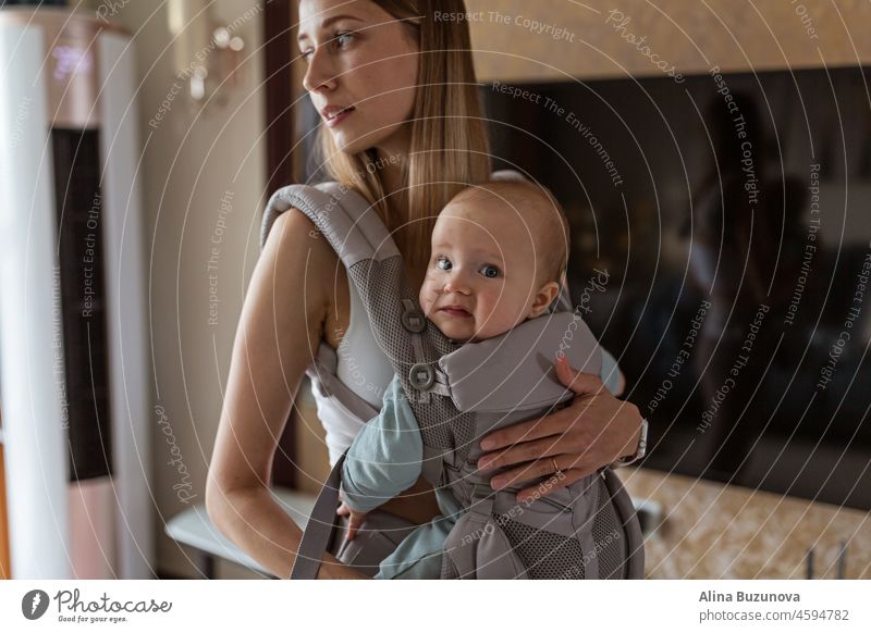 Young mother in sport clothing exercising at home with baby. Online training during coronavirus covid-19 quarantine. Stay fit and safe during pandemic lockdown. Sport, fitness, healthy concept