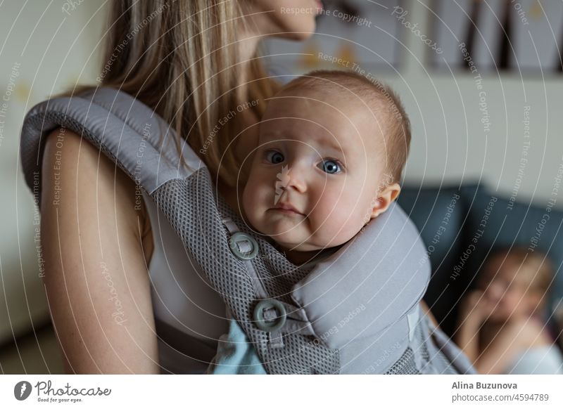 Young mother in sport clothing exercising at home with baby. Online training during coronavirus covid-19 quarantine. Stay fit and safe during pandemic lockdown. Sport, fitness, healthy concept