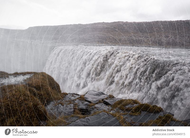 Powerful foaming waterfall falling from slope river landscape nature cliff environment power highland stream cascade flow reserve scenic rock stone dynamic