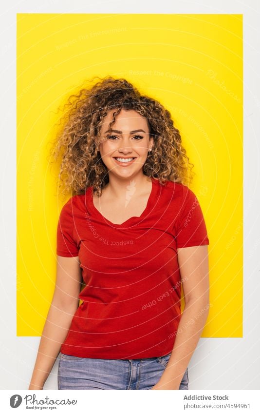 Smiling woman with curly hair in studio smile cheerful happy positive optimist young appearance casual style glad bright joy portrait colorful toothy smile