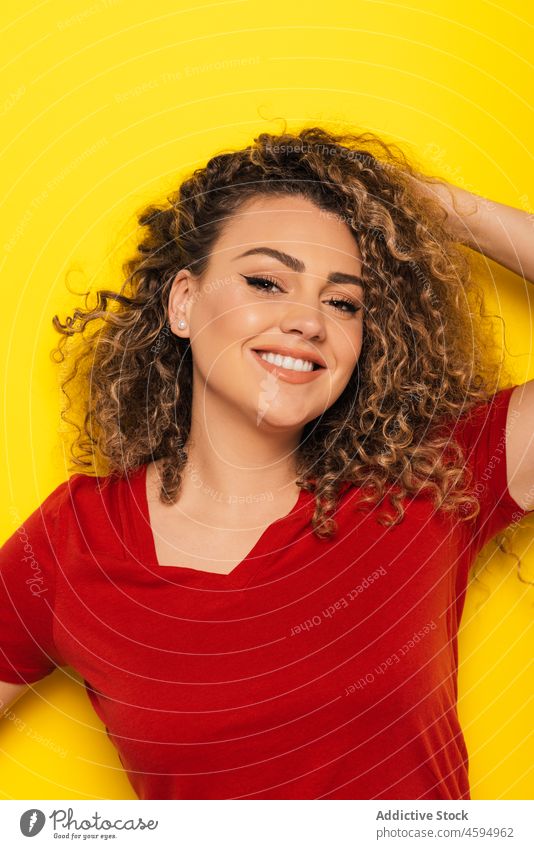 Smiling woman with curly hair in studio smile cheerful happy positive optimist young appearance casual style glad bright joy portrait colorful toothy smile