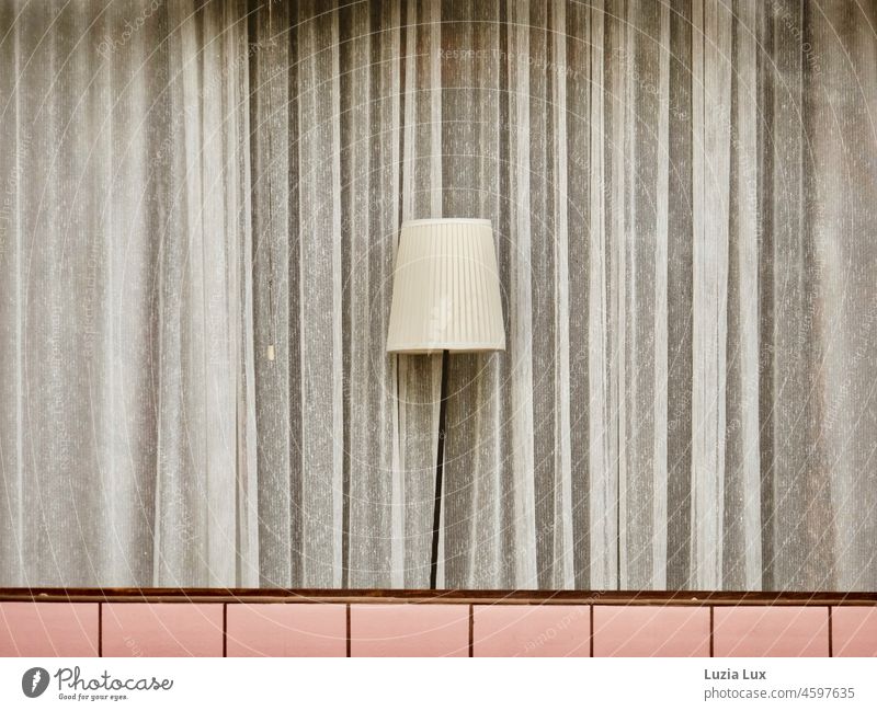 A former shop is used as a living space, in the shop window a delicate curtain and a gracefully bent floor lamp Lamp Window Shop window Standard lamp Lampshade