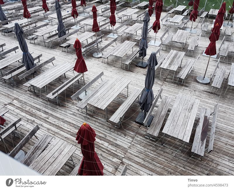 Deserted wooden gastronomy terrace with closed red and blue sunshades outside gastronomy Gastronomy Terrace Wood wooden terrace parasols Closed Gray Blue Red