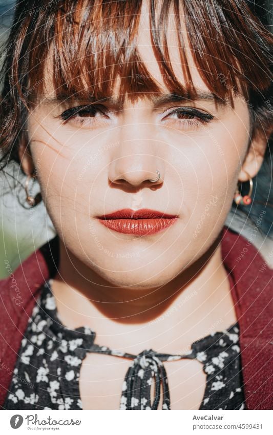 Serious beautiful young business woman outside office looking straight to camera very serious and worried, copy space for a text and ad.Trendy girl posing in the street background.Stress and anxiety